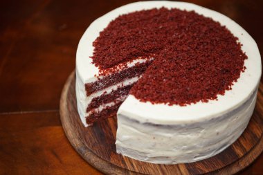 Lezzetli taze pişmiş kremalı pasta kırmızı bisküvi ile hizmet ve İtalyan restoranında ahşap plaka üzerinde kesmek. Kafe menüde lezzetli tatlı gıda maddesini. Öğle yemeği için doğal tatlı zevk