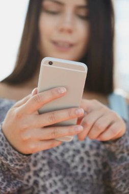 Genç kızın elinde büyük gümüş smartphone. Popüler modern cep telefonu modeli odak. 