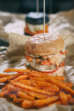 Havuç kızartması ile hazırlanmış lezzetli Amerikan burger fast food restoranda. Cafe menü yemek kapatın. Izgara sığır et pişirmek ve taze topuz ekmek cursty içinde servis yapın. Burger menü kapat