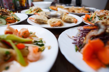 Egzotik yiyecek Restoran lezzetli Vietnam mutfağı menü. Kızarmış çıtır karidesli odaklanmak beyaz plaka üzerinde rulo. Taze renkli sebze salata ve deniz ürünleri Çin kafede. Asya gurme atıştırmalıklar