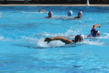 Atina - 7 Ekim,2012: Bayanlar sutopu şampiyonası. Kadınlar açık açık yüzme havuzunda sutopu oynarlar. Profesyonel sutopu takımı, ödül için savaş. Yakalayıcı topu kapıda yakalar. Takım gol.