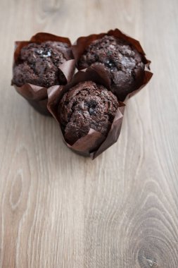 Tatlı ev yapımı çikolatalı muffin kekler kahverengi ahşap masa üzerinde. Brownie kek kahve, pişmiş tatlı için. Metni yerleştirmek için kopya alanı