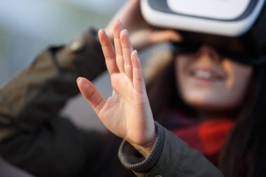 Mobil oyun uygulamaları açık için süper cool sanal gerçeklik gözlüklü genç kadın oynamak. Mobil apps ile yenilikçi vr kulaklık kullanın. Trendy artar gerçeklik oyun aygıtı kullanımda. 3D gözlük satın