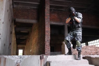 Strikeball oynayan otomatik silahlarile tam donanımlı askeri adam  