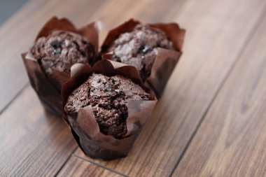 Taze pişmiş çikolata muffin Kupası pastalar ahşap masa üzerine kapatın. Brownie kek, taze ev yapımı pasta. Tatlı kahve, kakao hamuru şeker ve krema ile yemek