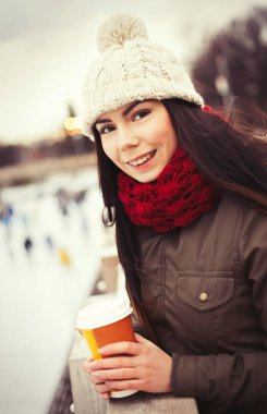Beyaz genç kız sıcak soğuk kış günü ısınmak için açık kahve iç. Mutlu kadın portre cappucino bardak ya da latte kağıt kupa dışında ile
