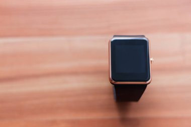 Ahşap arka plan üzerinde döşeme akıllı kol saati. Her zaman sağlar zarif yeni teknoloji bağlı kalmak 