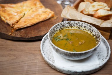 Geleneksel Gürcü Restoran akşam yemeği menüsü masaya servis. Sığır eti ve ahşap tabak üzerinde pişmiş et pastası ile egzotik mercimek çorbası. Lezzetli iş öğle yemeği Cafe