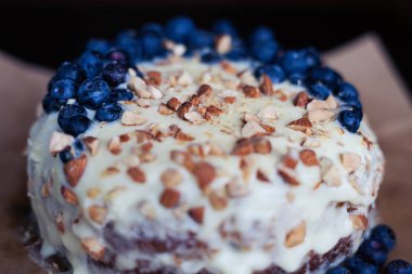 Yaban mersini kremsi Pie kahverengi bir kağıt üzerine badem ile kapatın. Çilek, hiçbir modelleri üzerinde odaklanmak.