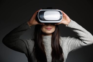Stüdyo portre genç kızın süper cool sanal gerçeklik gözlük mobil oyun uygulamalar için oynuyor. Mobil apps ile yenilikçi 3d vr kulaklık kullanın. Trendy artar gerçeklik oyun aygıtı kullanımda