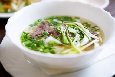 Lezzetli Vietnam geleneği restoran yemek pho bo çorba. Doğal egzotik yemek menüsü. Kase lezzetli Asya sıcak yemek sığır eti ve erişte ile hizmet
