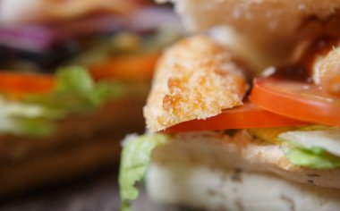 Fast food restoran menüsünde lezzetli sandviç. Taze aperatif kapatın. Kaşarlı tavuk şerit eti, dilimlenmiş domates sebze, salata yaprakları ve sos. Amerikan fastfood Cafe. Makro yakın çekim
