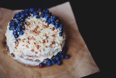 Yaban mersini kremsi Pie kahverengi bir kağıt üzerine badem ile kapatın. Çilek, hiçbir modelleri odaklan. Rustik solma film renkleri