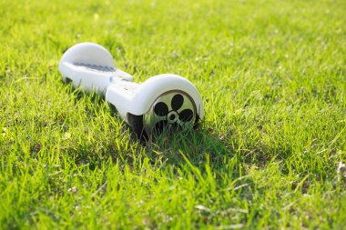 Beyaz elektrikli mini vurgulu kurulu motorla park yeşil çim. Eko şehir ulaşım pille, atmosfer, gezegen hakkında bakım için hava kirliliği üretmek