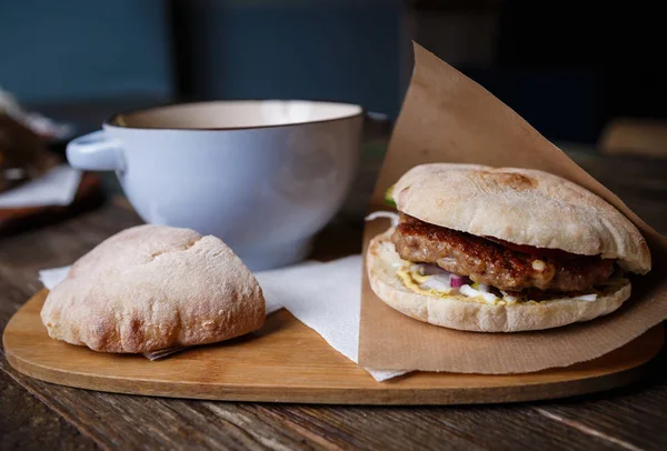 Traditional Serbian fast food restaurant food.Creamy soup, fresh meat burger in crusty bun bread served on wooden plate on rustic table.Exotic cafe food background