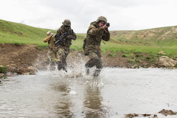 Military assistance.Army teamwork.Armed soldiers in camouflage of Ukrainian army in combat uniform.War in Eastern Ukraine.Heavy ammunition,automatic rifle