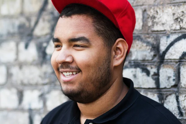 Kırmızı Arka Beyzbol Şapkalı Gülümseyen Genç Siyah Erkek Portresi Bir — Stok fotoğraf