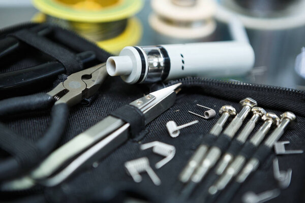 Vape shop.Modern vaping device maintenance & upgrade parts in close up.Buy popualr ecig vaper device.Electronic cigarette gadget for smoking ejuice.New box mod clearomizer