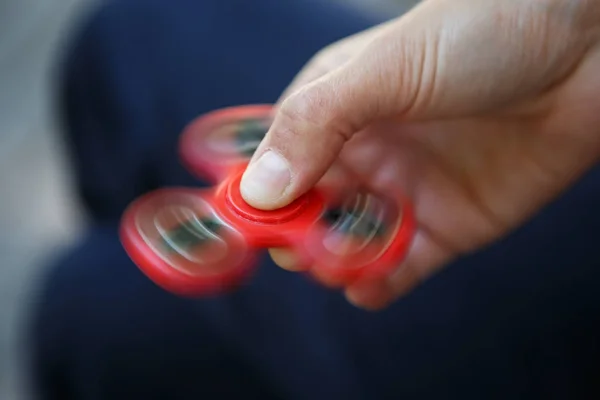 Woman spinning the spinner device in her fingers.Blurred fast motion.Super popular toy device in 2017.Enjoy spinning new fidget gadget for fun.Hobby & entertainment object for good reaction