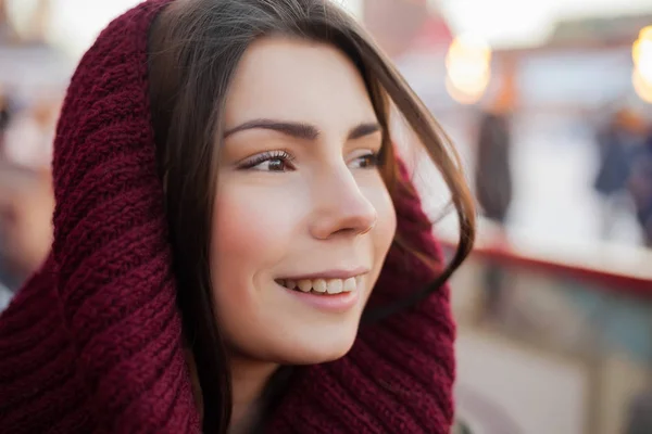 Fashionable young girl wear red knit scarf headwear on her head outdoor.Pretty happy white woman portrait.Close up,attractive female model