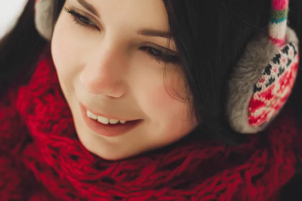 年轻的白人女孩的肖像在耳罩微笑 积极的小鸡在温暖的冬衣 红色围巾和五颜六色的耳机 — 图库照片