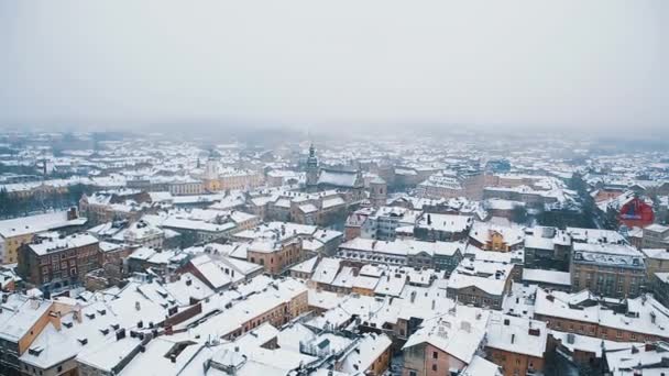 ウクライナ西部のリヴィウ市の美しい空中ドローン映像は 寒い冬の日に上から撮影しました 南ヨーロッパの観光客のためのJanuary Travel目的地で雪に覆われた旧市街の屋根 — ストック動画