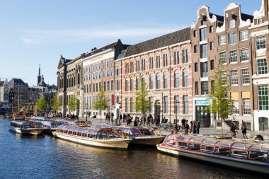 Amsterdam,Hollanda-27 Nisan,2019: Amsterdam şehrinin tarihi merkezinde Amstel Nehri'nin kanalında yüzen yüzen tekneler. Popüler Hollandalı tekne evleri su üzerinde sürüklenen, bir iskelede demirlemiş