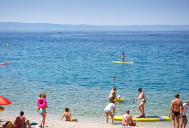 Makarska, Hırvatistan-16 Haziran 2017: Hırvat Rivierası 'nda Adriyatik Denizi kıyısında popüler bir turist alanı. halk plaj tatil uluslararası turistler ile. Yaz gezisi için seyahat yeri