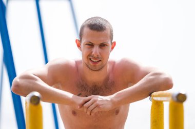 yakışıklı genç adam sokak egzersiz sahilde bir aydınlık yaz günü yapıyor..