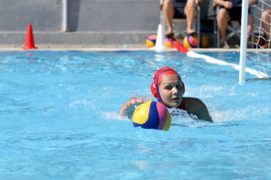 Atina - 7 Ekim,2012: Bayanlar sutopu şampiyonası. Kadınlar açık açık yüzme havuzunda sutopu oynarlar. Profesyonel sutopu takımı, ödül için savaş. Yakalayıcı topu kapıda yakalar. Takım gol.