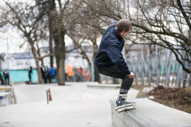 Moskova - 25 Mart, 2017: genç agresif Inline patenci adam eziyet çıkıntının üzerinde aşırı hatlı tekerlekli paten açık skate park sokak skate Yarışması sırasında demiryolu ile