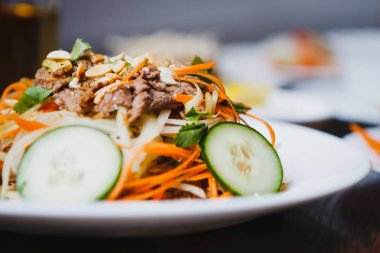 Sığır eti, taze salatalık ve Çin havuç ile lezzetli Asya salata tadını çıkarın. Vietnam restoranı geleneksel gıda ile egzotik yemek deneyin. Yakın çekim, salataya odaklan