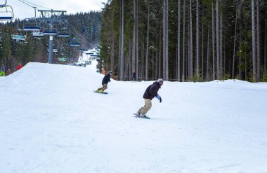 Bukovel, Ukrayna-19 Mart, 2018: Bukovel kar Park resort özel Kayak yolda gemide Snowboarder atlet sürmek. Güney Avrupa'da aşırı kış sporları. Tatil için seyahat hedef