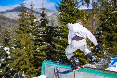 Bukovel, Ukrayna - 19 Mart, 2018: Snowboard pro binici kış Park demiryolu yamaç tarzı yarışmasında eziyet hüner gerçekleştirir.