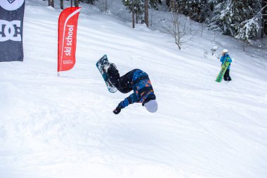 Bukovel, Ukrayna-19 Mart, 2018: Genç snowboard atlet rampa Kayak Park Bukovel kış kar tahtada yapmak hava hüner Park.Sportsman yarışmada doğa kış sporları sırasında atlar