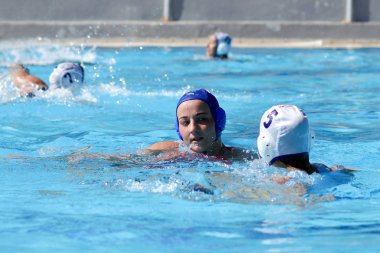 Atina - 7 Ekim,2012: Bayanlar sutopu şampiyonası. Kadınlar açık açık yüzme havuzunda sutopu oynarlar. Profesyonel sutopu takımı, ödül için savaş. Yakalayıcı topu kapıda yakalar. Takım gol.