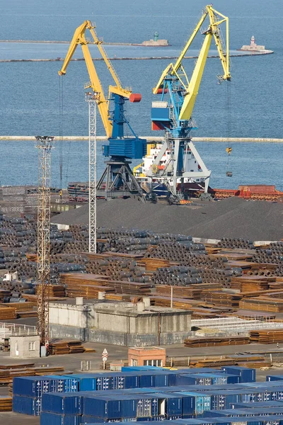 在商业码头工作的两个起重机 集装箱码头和金属的存储是可见 — 图库照片