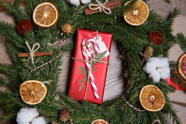 新年プレゼントの装飾的な赤いギフト パッケージ ボックス モミの木 クリスマス スティック パイン装飾的な花輪に囲まれて飾られています オーバーヘッド フラット レイアウト — ストック写真