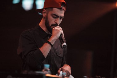 Moskova - 20 Ekim, 2016: Rap şarkıcı şarkı sahne gece kulübü. Hip hop müzik sanatçı şarkı mikrofon sahnede. Rapçi parlak konser aydınlatma.