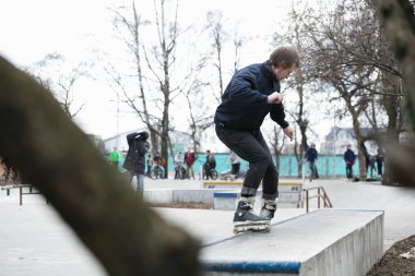 Moskova - 25 Mart, 2017: genç agresif Inline patenci adam eziyet çıkıntının üzerinde aşırı hatlı tekerlekli paten açık skate park sokak skate Yarışması sırasında demiryolu ile