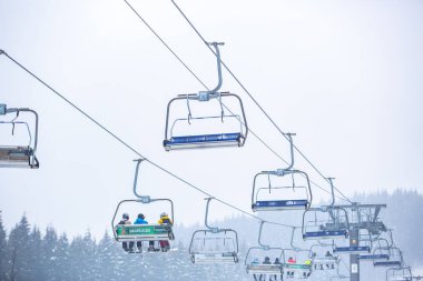 Bukovel, Ukrayna - 19 Mart, 2018: sandalye Asansör kayakçı ve Snowboard düşkünleri kış tatil için. Etkin turistler üzerinde snowboard binmek için Asansör ve kayaklar Bukovel Winter Park Karpat Dağları