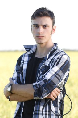 genç şarkıcı mikrofon ile açık havada aydınlık yaz gününde poz 