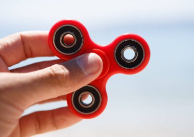 Parmak spinner oyuncak yatakları üzerinde. Süper popüler iplik aygıt. Topluca spinners ile oynarken zevk. Serin plastik Gadget eğlenmek için döner. Erkek el içinde güzel mekanik bir karşı oyun 