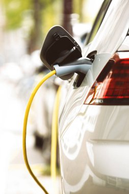 Yeni hibrid araç pili kablo üzerinden elektrik enerjisi ile şarj eder. Modern araç şarj. Hava kirliliği ile temiz şehir ulaşım