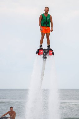 Odessa, Ukrayna-21 Ağustos, denizde hydroflyer vurgulu gemide 2017:Young kişini. Trendy sinek Kurulu jetboots ayakları üzerinde. Modern Jet artyakıcıları vurgulama kurulu Aqua scooter tekne ile güçlendirilmiş
