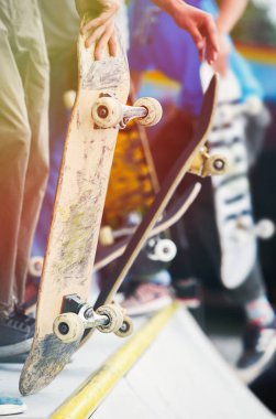 Patenciler çocuklar yerel skatepark güneşli yaz günde açık yarışmasında katılmaktadır. Kaykaycı adam eski güverte ellerini, binmek ve hile yapmak hazır tutar. Popüler gençlik spor ve yaşam tarzı 