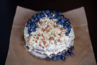 Yaban mersini kremsi Pie kahverengi bir kağıt üzerine badem ile kapatın. Çilek, hiçbir modelleri odaklan. Rustik solma film renkleri