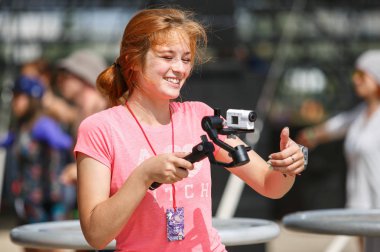 Odessa, Ukrayna-23 Ağustos 2017: Eylem Kamera ile operatör kız. Mutlu genç kız stabilizatör kavrama portableaction cam ile video blog görüntüleri vuruyor. Taşınabilir Sony video kamera 