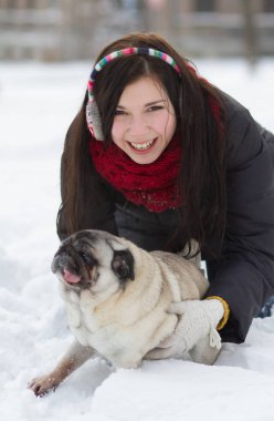 Genç giel komik pug yavrusu karda oynamaya 