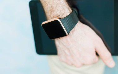 Her zaman internet ve sosyal medya - trendy akıllı izlemek ve tablet pc ile bağlanması için iki modern dijital cihazlar tutan erkek el. 